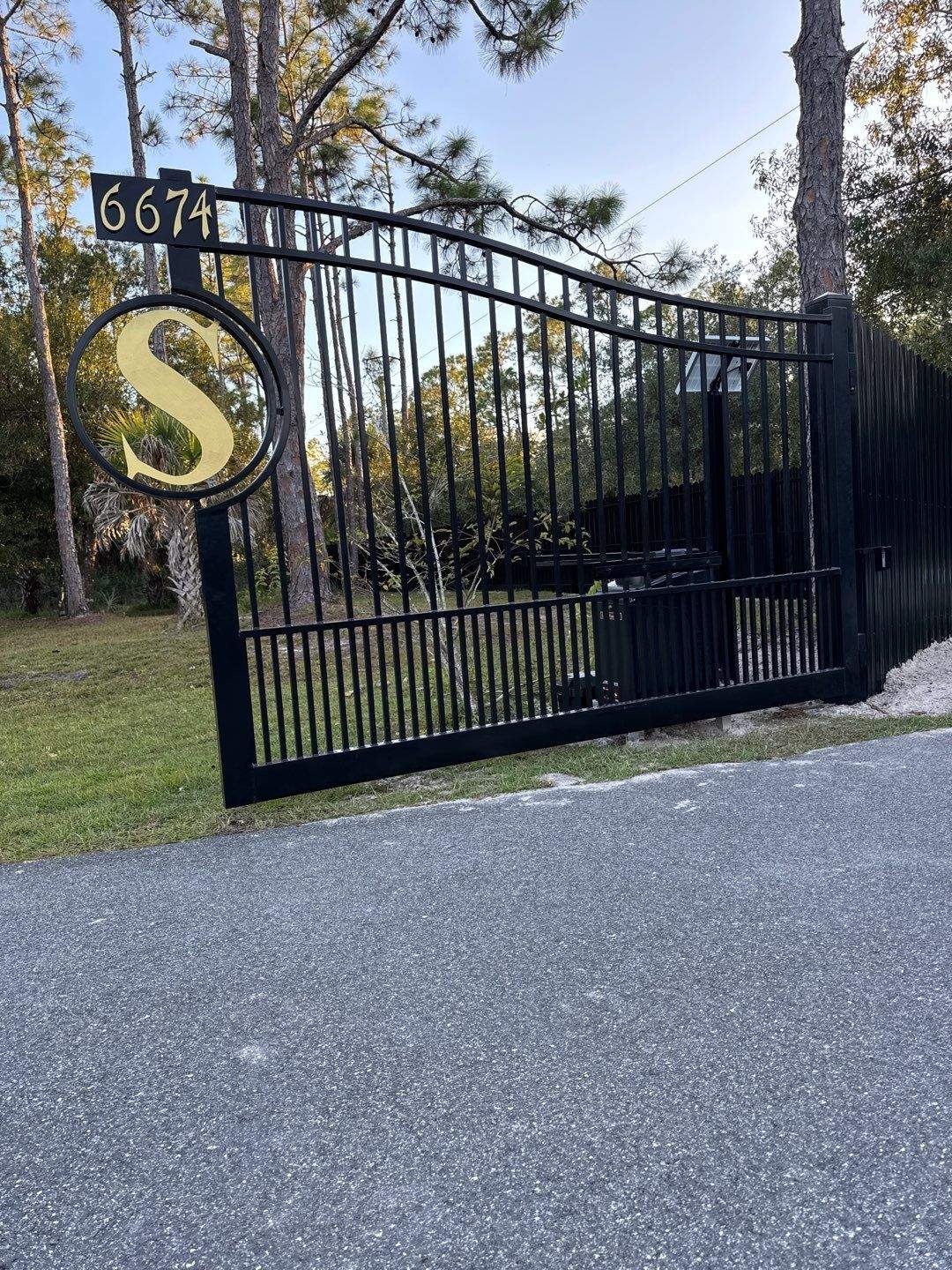 Black estate gate with monogram